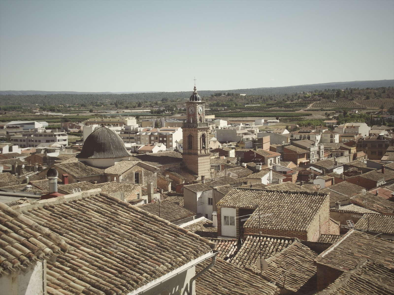 Tejados de Navarrés con la cúpula y el campanario de la iglesia y el valle al fondo